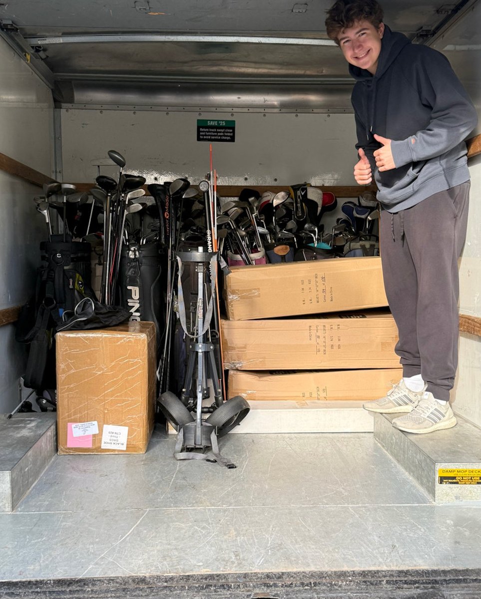 Grant Stastney with collected golf clubs in a truck for delivery
